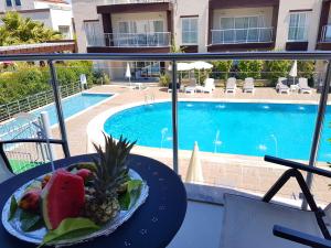 a plate of fruit on a table next to a pool at Odyssey Residence Apartments in Fethiye