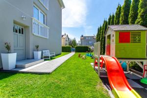 een tuin met een speelgoedhuis en een speeltuin bij Willa Verano in Karwia