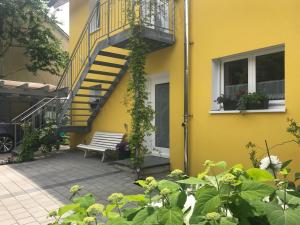 a yellow building with a staircase and a bench at Ferienwohnung Maria in Überlingen