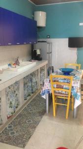 uma cozinha com um balcão, uma mesa e um lavatório em Casa Sciatu di Mari em Portopalo