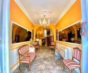 salon z pomarańczowymi ścianami i krzesłami oraz żyrandolem w obiekcie Hôtel U Palazzu & Spa w mieście Venaco