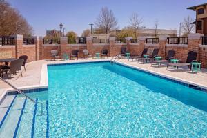 a large swimming pool with chairs and a table at Hyatt Place Florence Downtown in Florence