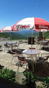 un grupo de mesas y sillas bajo una sombrilla en Hostal La Collada de Aralla, en Aralla de Luna