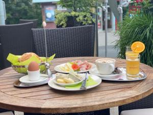 einen Holztisch mit Teller mit Speisen und Getränken darauf in der Unterkunft Konditorei Mandl in Bruck an der Mur