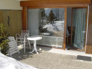 a screened in porch with a table and chairs at Roc d'Orsay F66 in Leysin