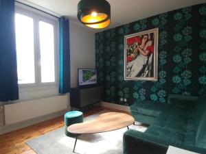 una sala de estar con un sofá y una mesa en Confort douceur et calme dans Grenoble, en Grenoble