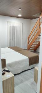 アルガニルにあるFonte d' Amandosのベッドルーム1室(大型ベッド1台、階段付)