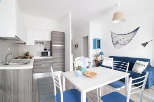uma cozinha e sala de estar com uma mesa branca e cadeiras em Casa Gatto Miao em Rapallo
