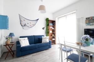 uma sala de estar com um sofá azul e uma mesa em Casa Gatto Miao em Rapallo