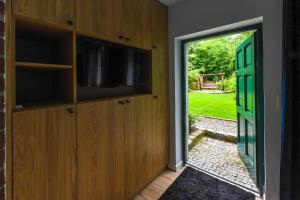 eine Tür, die in ein Zimmer mit einem TV und einer Tür führt in der Unterkunft Aulichówka - Dom Wakacyjny i Squash in Gryżyna