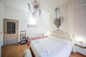 a white bedroom with two beds and a window at Casale D' Or in Palermo