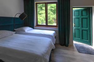 sypialnia z 2 łóżkami i zielonymi drzwiami w obiekcie Aulichówka - Dom Wakacyjny i Squash w Gryżynie