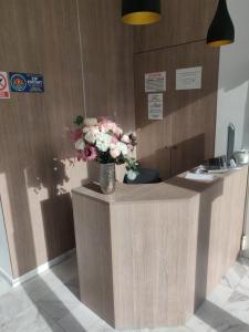a reception desk with a vase of flowers on it at Mamaia Beach Side in Mamaia