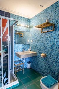 bagno piastrellato blu con lavandino e doccia di Captains Log House a Baleal