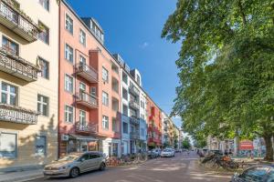 una calle con edificios y coches estacionados en la calle en BENSIMON apartments Prenzlauer Berg, en Berlín