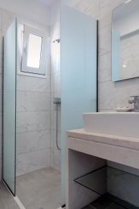 y baño con ducha, lavabo y espejo. en Aegean Horizon apartments, en Gennadi