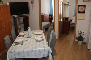 a dining room with a table with plates and dishes on it at Apartment Retro III in Koper