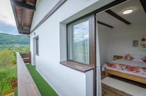 a bedroom with a window and a bed on a balcony at Acasa la Mariuca in Bran