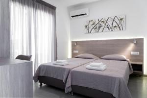 een slaapkamer met een groot bed en 2 handdoeken bij Aegean Horizon apartments in Gennadi