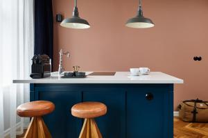 a kitchen with a blue island with two stools at Kvosin Downtown Hotel in Reykjavík