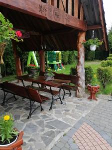 cenador de madera con mesa de picnic y bancos en Willa u Magdy, en Zakopane