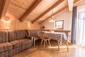 un soggiorno con un divano, un tavolo e delle sedie di Tlisüra a La Villa