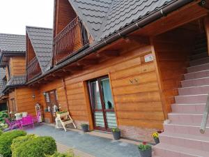 a wooden house with a patio and a balcony at Willa u Magdy in Zakopane