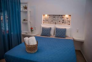 a bedroom with a blue bed with a basket on it at PERIVOLI 4-CHORA(5min away from the center by car) in Agkidia
