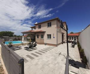 a house with a patio and a swimming pool at AS Apartmani "Chocolate" in Peroj