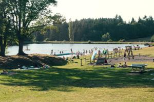a group of people in a park near a lake at Le Cadran So'Lair in Saint-Germain-lʼHerm