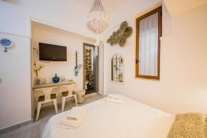 a room with a bed and a table and a television at Casale D' Or in Palermo