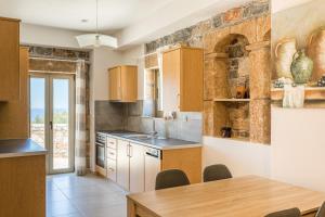 una cucina con mobili in legno e tavolo di Villa Elly a Stoupa