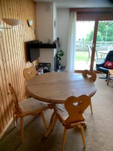 uma mesa de madeira e cadeiras numa sala de estar em Roc d'Orsay E52 em Leysin