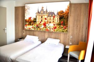 a room with two beds and a picture of a castle at Kyriad Hotel Tours Centre in Tours