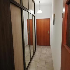 a hallway with a mirror and a door in a room at Apartament nad Jeziorem Sławskim in Radzyń