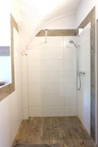 een badkamer met een douche met witte tegels bij Ferienwohnung Toscana am Berzdorfer See in Jauernick-Buschbach