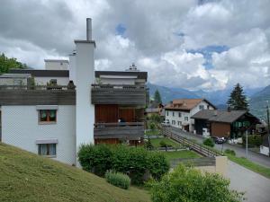 a white house with a cross on top of a hill at Roc d'Orsay E52 in Leysin