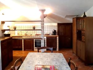 uma cozinha com uma mesa e um fogão forno superior em San Filippo em Acquapendente