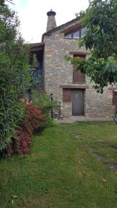 uma casa de tijolos com um portão e uma garagem em Apartamentos La Borda Castillon em Tierrantona