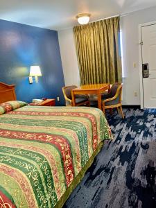 a hotel room with two beds and a table at Scottish Inns Westcott Street in Houston