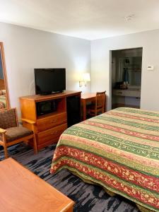 a hotel room with two beds and a flat screen tv at Scottish Inns Westcott Street in Houston