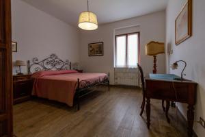 a bedroom with a bed and a desk and a window at Casa Vì - Toscana, Lunigiana, near Cinque Terre in Fivizzano