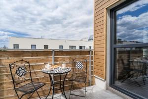 a patio with a table and chairs on a balcony at Flow Apartments Toruń in Toruń