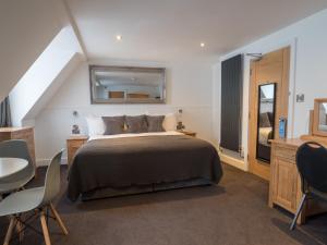 a bedroom with a bed and a table and chairs at Carlton Hotel in Ilfracombe