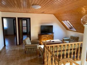 een woonkamer met een televisie en een tafel en stoelen bij Szomszéd Ház in Keszthely
