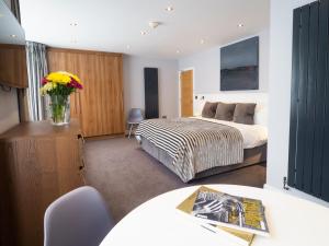 a bedroom with a bed and a vase of flowers at Carlton Hotel in Ilfracombe
