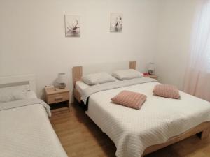 twee bedden in een kamer met witte muren bij Apartment Antea in Šibenik