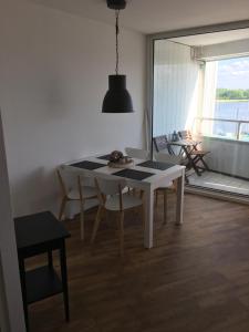 a dining room with a white table and chairs at Apartment 6, OG 3 in Schleswig +5 photos
