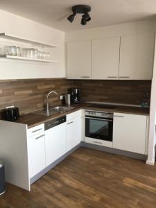 a kitchen with white cabinets and a sink at Apartment 6, OG 3 in Schleswig