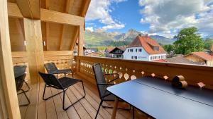 a balcony with chairs and a table and a view of mountains at Haus Akelei in Fischen